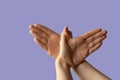 Silhouette of a hand gesture similar to a bird flying on a lilac background Royalty Free Stock Photo