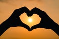 Silhouette hand in heart shape with sunrise on the sky background. love concept Royalty Free Stock Photo