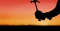 Silhouette hand holding hammer during sunset Royalty Free Stock Photo