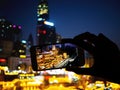 Silhouette hand holding mobile phone taking photograph night landscape of Hongyadong shopping complex at Chongqing, China Royalty Free Stock Photo