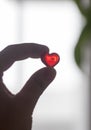 Silhouette hand holding plastic heart with blurred background Royalty Free Stock Photo