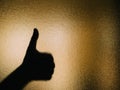 Silhouette of hand making a thumbs up on a glass Royalty Free Stock Photo