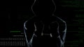 Silhouette of handcuffed anonymous standing in front of animated computer code