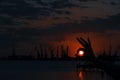 Silhouette hands against the sun, sea port