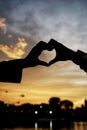 silhouette of hands forming a heart or love symbol on a sunset background Royalty Free Stock Photo