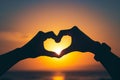 Silhouette of hands forming a heart shape around the sun at sunset, created by Generative AI Royalty Free Stock Photo