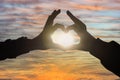 Silhouette of hands making heart with sun inside, close-up Royalty Free Stock Photo