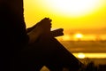 Silhouette of the hands of woman praying to God in the nature witth the Bible at sunset, the concept of religion and spirituality Royalty Free Stock Photo