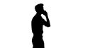 Silhouette Handsome man having phone talk while walking. Royalty Free Stock Photo