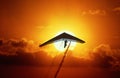 Silhouette of a hang glider at sunset