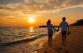 Silhouette of happy Asian couple hands holding and walking together on the beach while golden sunset time evening Royalty Free Stock Photo