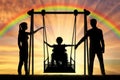 Silhouette of a happy child is a disabled person in a wheelchair on an adaptive swing Royalty Free Stock Photo