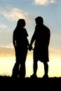 Silhouette of Happy Couple Holding Hands and Talking at Sunset Royalty Free Stock Photo