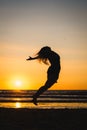 Silhouette of a happy dancer girl jumping the sunset Royalty Free Stock Photo