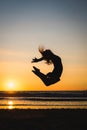 Silhouette of a happy dancer girl jumping the sunset Royalty Free Stock Photo