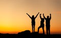 Silhouette of a happy family with arms raised up against beautiful sky. Summer Sunset Royalty Free Stock Photo