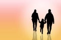 The silhouette of a happy family is father, mother and son walking in sunset. Royalty Free Stock Photo