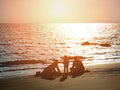 Silhouette happy family playing with sand on summer sunset beach Royalty Free Stock Photo