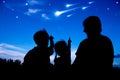 Silhouette of happy family sitting and looking sky at comets.