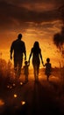 Silhouette happy family walking in a field at sunset Royalty Free Stock Photo