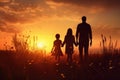 Silhouette of a happy family walking in the field at sunset, Silhouette of young couple hiker were standing at the top of the Royalty Free Stock Photo