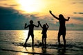 Silhouette of happy family who playing on the beach at the sunset time Royalty Free Stock Photo