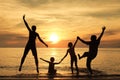 Silhouette of happy family who playing on the beach at the sunset time. Royalty Free Stock Photo