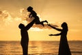 Silhouette of happy family who playing on the beach at the sunset time. Royalty Free Stock Photo