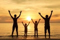 Silhouette of happy family who playing on the beach at the sunse Royalty Free Stock Photo