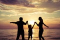 Silhouette of happy family who playing on the beach at the sunset time. Royalty Free Stock Photo