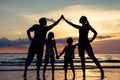 Silhouette of happy family who playing on the beach at the sunset time. Royalty Free Stock Photo