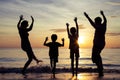 Silhouette of happy family who playing on the beach at the sunset time. Royalty Free Stock Photo