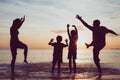 Silhouette of happy family who playing on the beach at the sunset time. Royalty Free Stock Photo