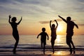 Silhouette of happy family who playing on the beach at the sunset time. Royalty Free Stock Photo