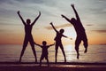 Silhouette of happy family who playing on the beach at the sunset time. Royalty Free Stock Photo