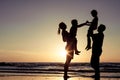 Silhouette of happy family who playing on the beach at the sunset time. Royalty Free Stock Photo