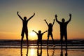 Silhouette of happy family who standing on the beach at the suns Royalty Free Stock Photo