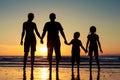 Silhouette of happy family who standing on the beach at the suns Royalty Free Stock Photo