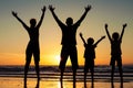 Silhouette of happy family who standing on the beach at the suns Royalty Free Stock Photo