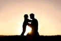 Silhouette of Happy Father and his Little Child Smiling and Playing at Sunset