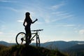 Young happy woman riding bicycle in the mountains at summer day Royalty Free Stock Photo