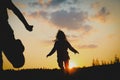 Silhouette of happy girl and boy running at sunset Royalty Free Stock Photo