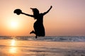 Happy girl jumping on the beach at sunset Royalty Free Stock Photo