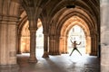 Silhouette of happy girl jumping high up in cloisters of Glasgow Royalty Free Stock Photo