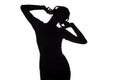 Silhouette of a happy girl listening to music in headphones, figure of young woman with hands up relaxing on a white isolated