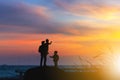 Silhouette of Happy Grandfather granddaughter and grandchild playing on stone at beach evening sunset background Royalty Free Stock Photo