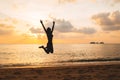 Silhouette of happy joyful woman jumping at the beach against the sunset Royalty Free Stock Photo