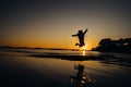 Silhouette of happy joyful woman jumping and having fun at the beach at sunset/sunrise.Freedom and happiness.Holiday vacation Royalty Free Stock Photo