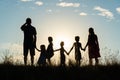 Silhouette of a happy large family at sunset.