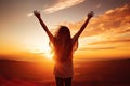 Silhouette of happy woman with raised hands over sunset sky background, Excited girl standing and celebrating success on a sunset Royalty Free Stock Photo